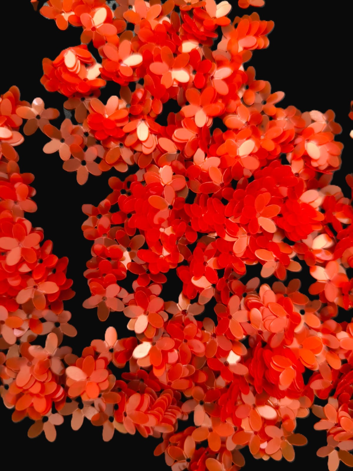 Paillettes petites fleurs oranges légèrement transparentes 9 mm