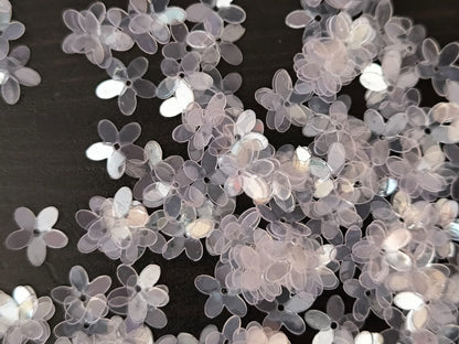 Paillettes petites fleurs transparentes reflet rose 9 mm